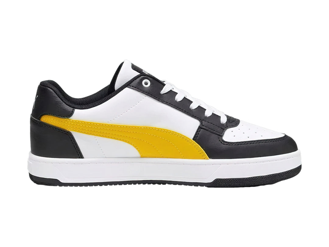 Tenis PUMA Caven 2.0 en colores blanco y negro con franja amarilla y suela blanca.