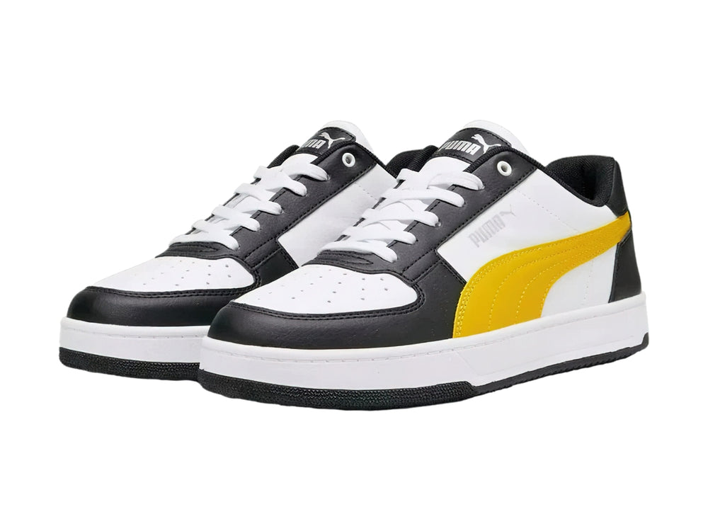 Tenis PUMA Caven 2.0 en colores blanco y negro con franja amarilla y suela blanca.