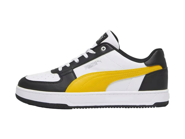 Tenis PUMA Caven 2.0 en colores blanco y negro con franja amarilla y suela blanca.