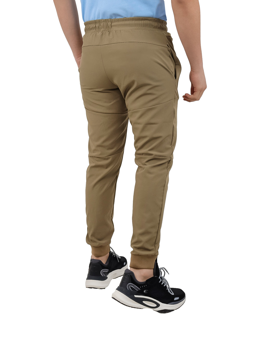Hombre vistiendo pantalones deportivos K-Swiss color arena con cintura elástica y corte ajustado.
