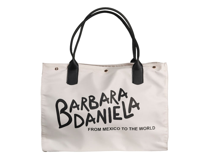 Bolso de hombro color hueso con asas negras y texto impreso en negro que dice Barbara Daniela.