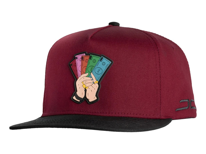 Gorra snapback color rojo con visera negra y un parche bordado frontal de manos sosteniendo billetes.
