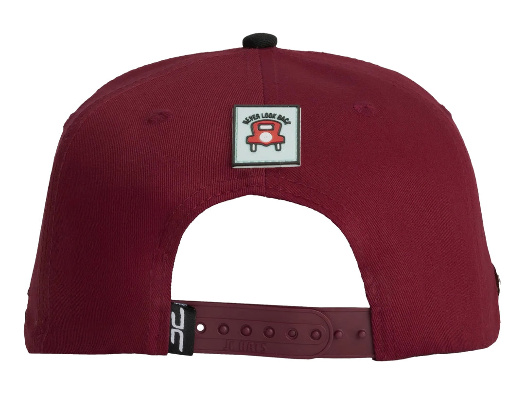 Gorra snapback color rojo con visera negra y un parche bordado frontal de manos sosteniendo billetes.