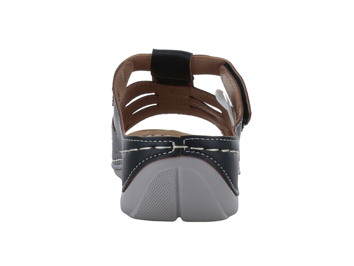 Sandalia Comfort Fit color negro con costuras blancas decorativas y correa ajustable en el empeine.