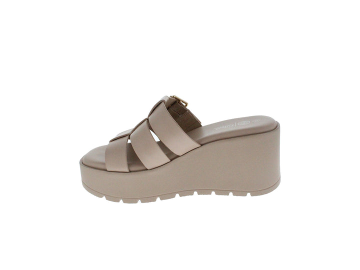 Sandalia de plataforma color beige con hebilla dorada y suela gruesa.