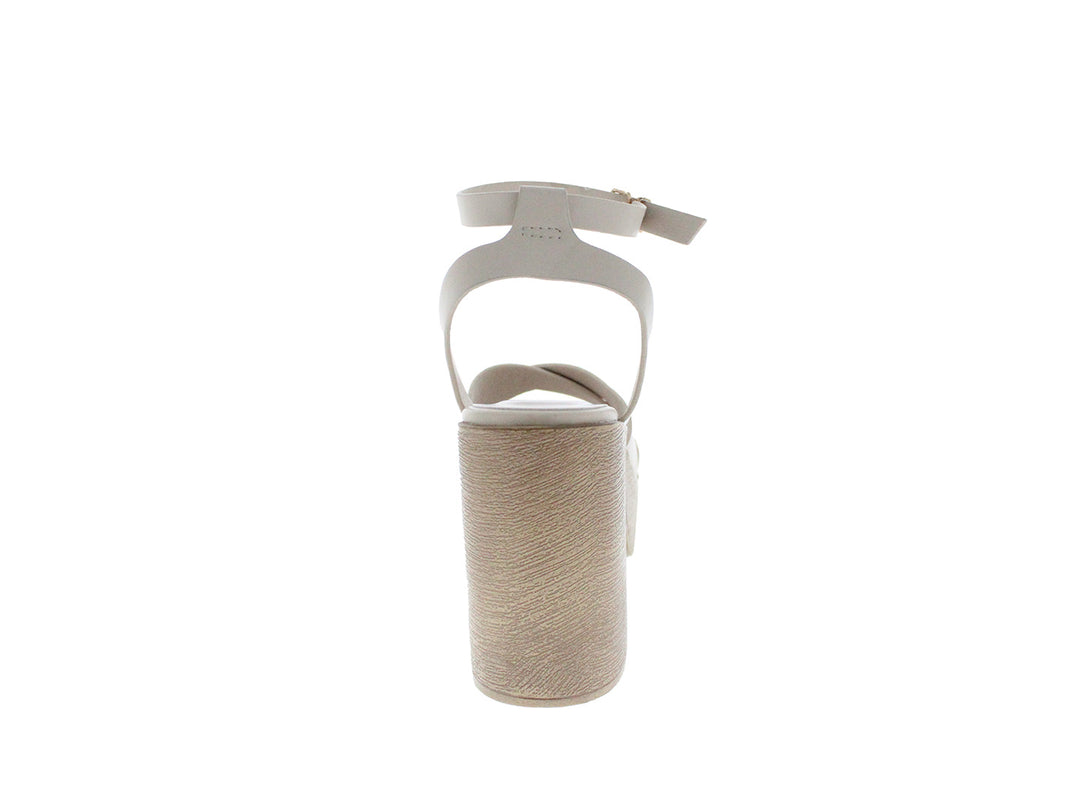 Sandalia de plataforma color beige con tacón grueso y correa ajustable al tobillo.