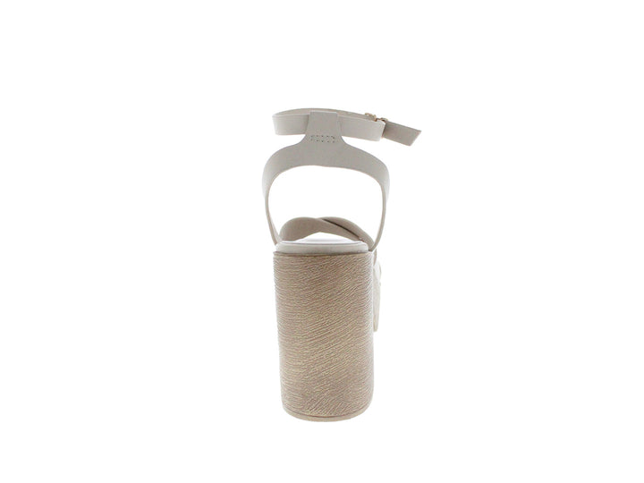 Sandalia de plataforma color beige con tacón grueso y correa ajustable al tobillo.