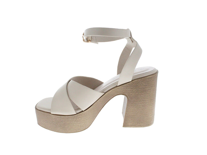 Sandalia de plataforma color beige con tacón grueso y correa ajustable al tobillo.