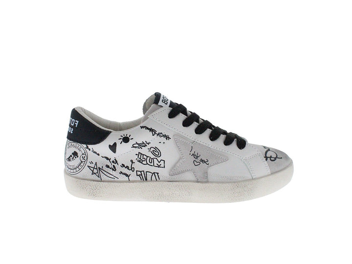 Tenis blancos con cordones negros y dibujos estilo graffiti en los laterales.