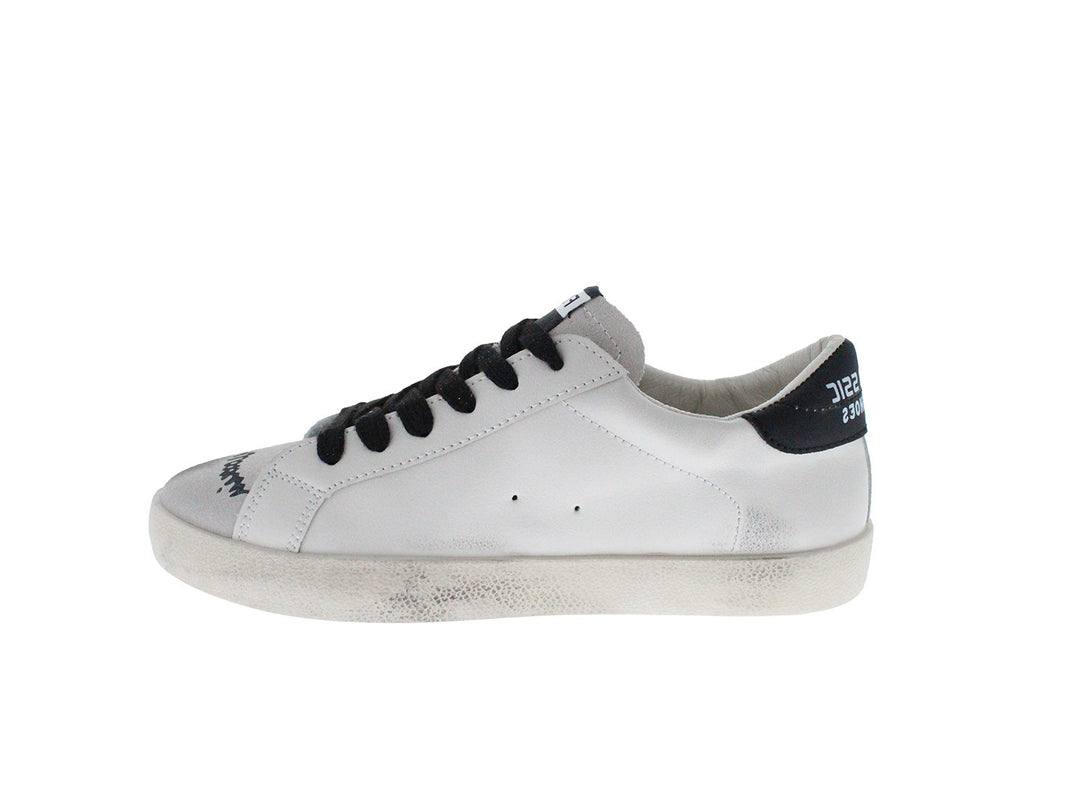 Tenis blancos con cordones negros y dibujos estilo graffiti en los laterales.