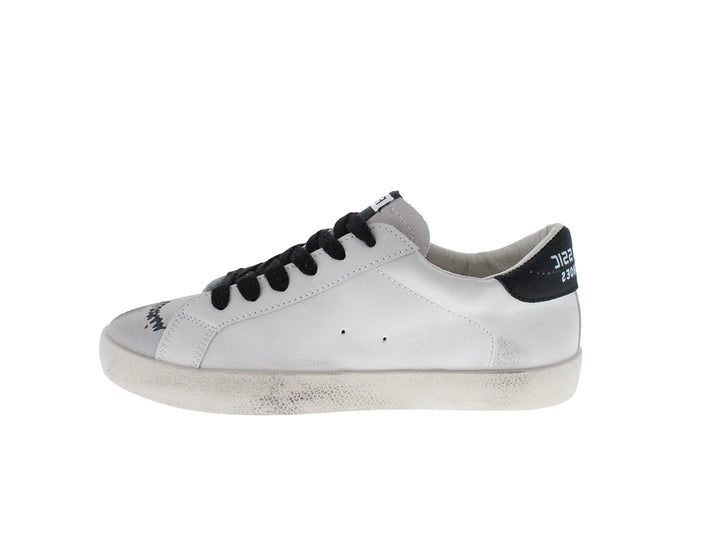 Tenis blancos con cordones negros y dibujos estilo graffiti en los laterales.