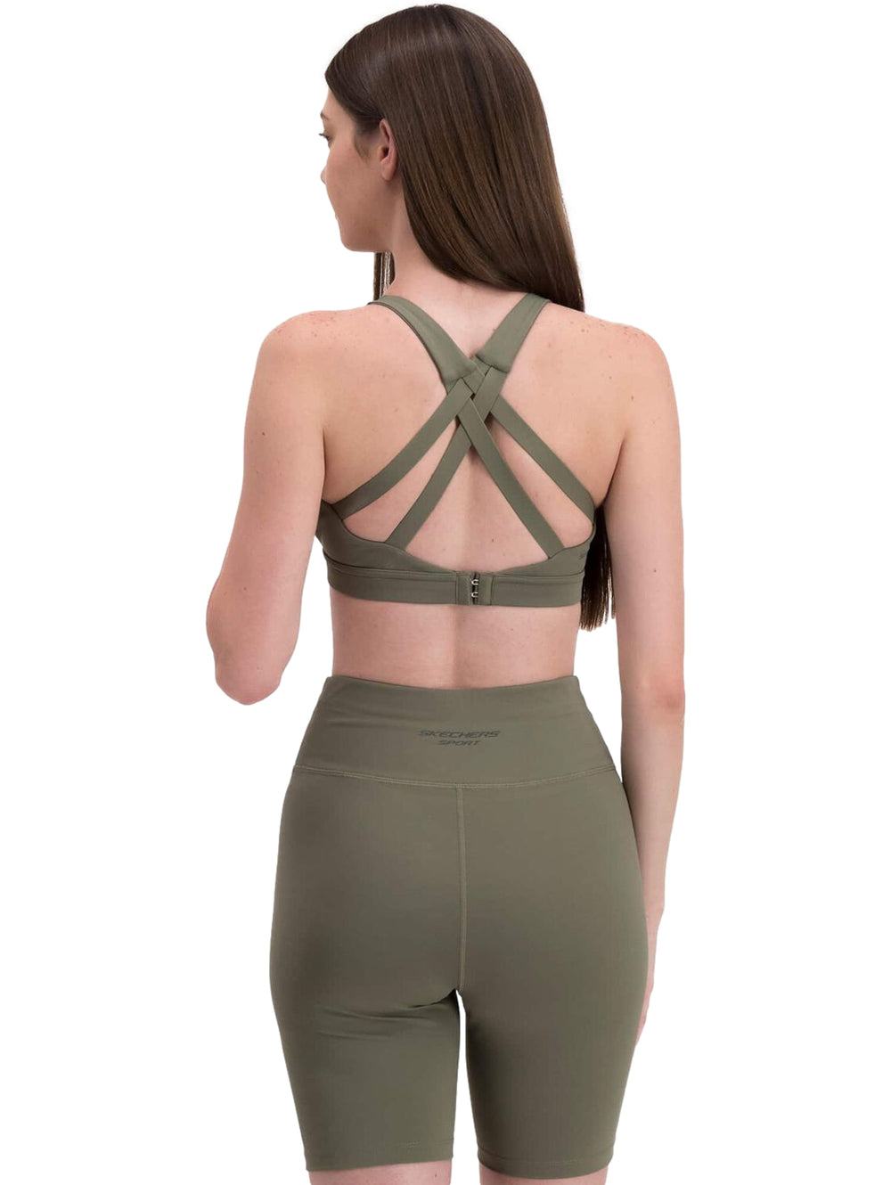 Mujer vistiendo un conjunto deportivo de color verde oliva compuesto por un top corto y shorts ajustados de Skechers.