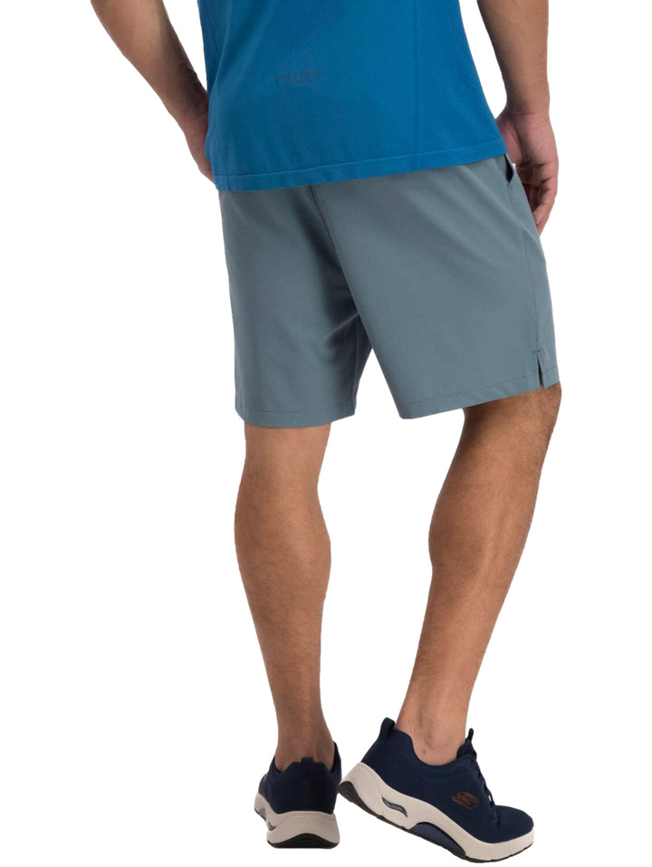 Hombre vistiendo un short deportivo de color azul oscuro marca Skechers con calzado deportivo a juego.
