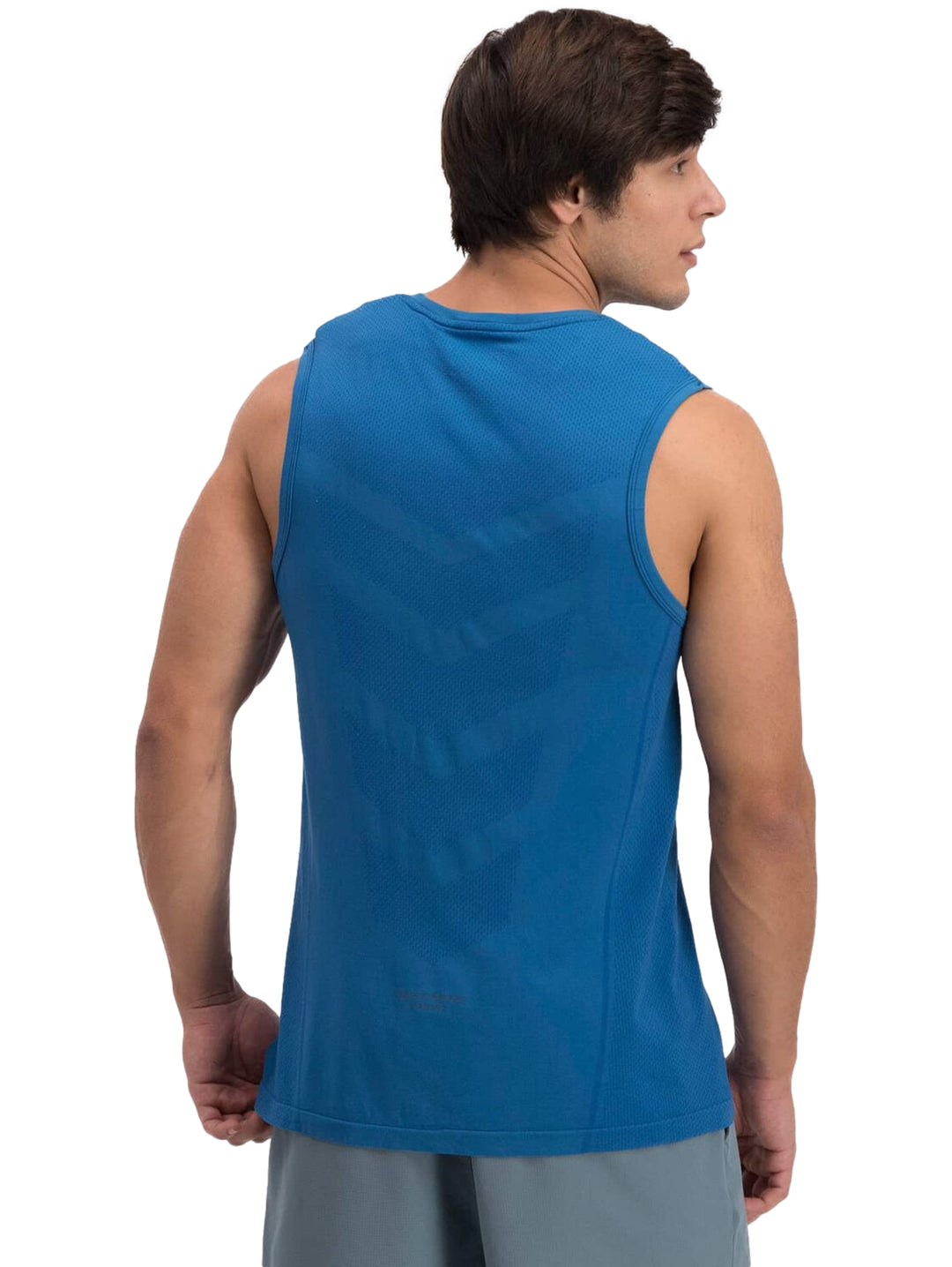 Hombre vistiendo una camiseta deportiva sin mangas de color azul marca Skechers.