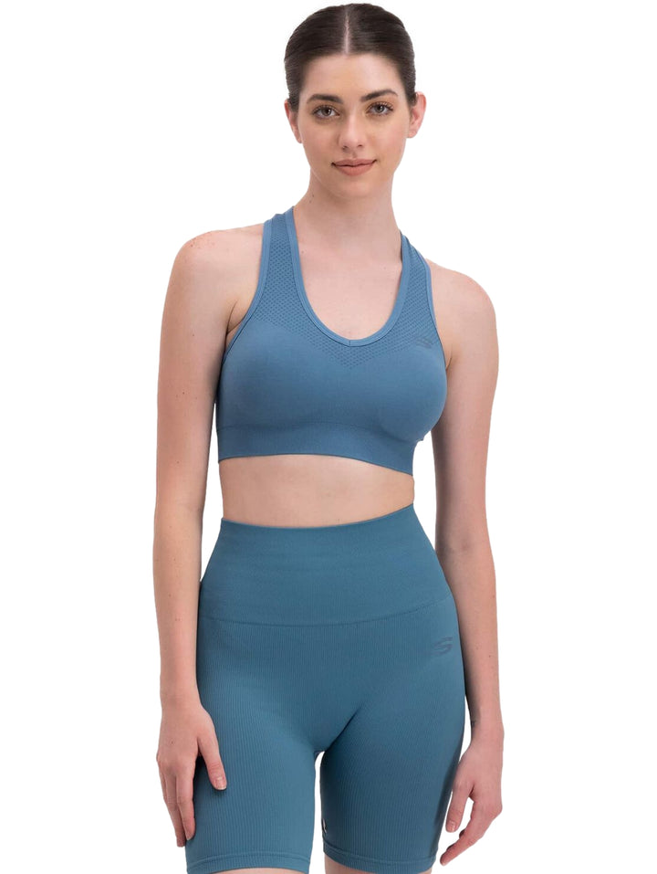 Conjunto deportivo azul de Skechers compuesto por un top corto y shorts ajustados para mujer.