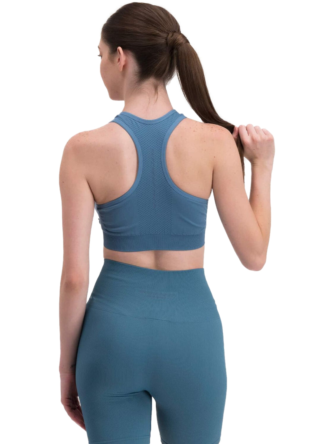 Conjunto deportivo azul de Skechers compuesto por un top corto y shorts ajustados para mujer.