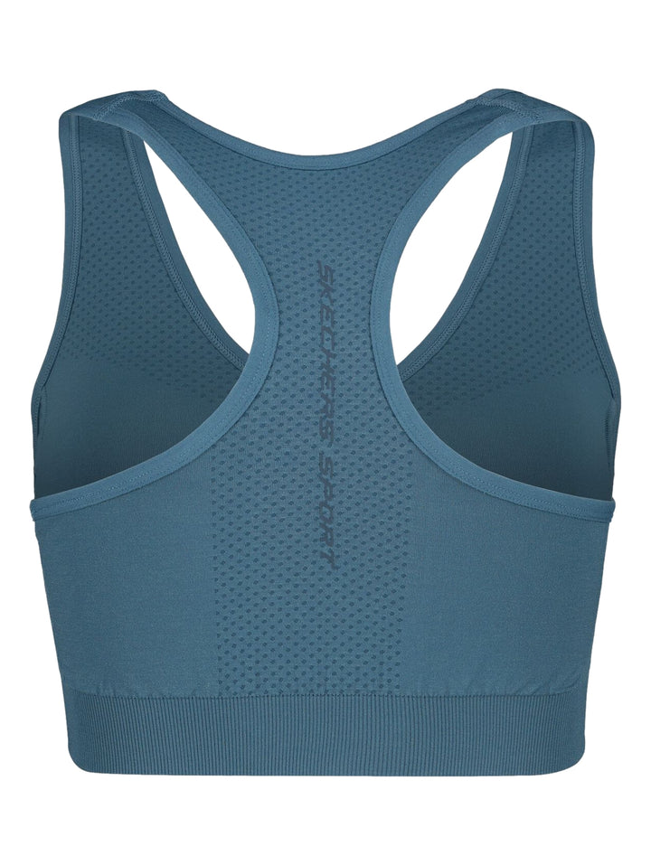 Conjunto deportivo azul de Skechers compuesto por un top corto y shorts ajustados para mujer.