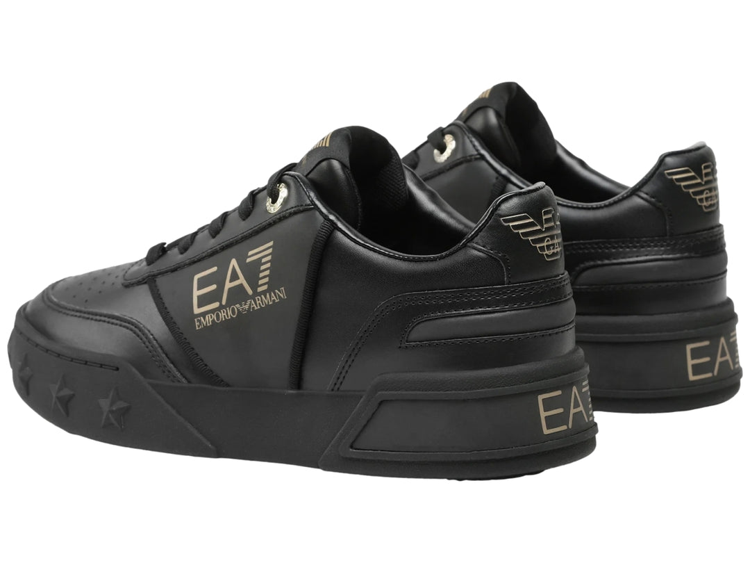 Tenis negros Emporio Armani con logotipo dorado EA7 y estrellas grabadas en la suela.