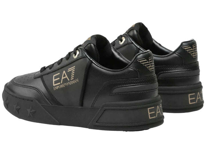 Tenis negros Emporio Armani con logotipo dorado EA7 y estrellas grabadas en la suela.