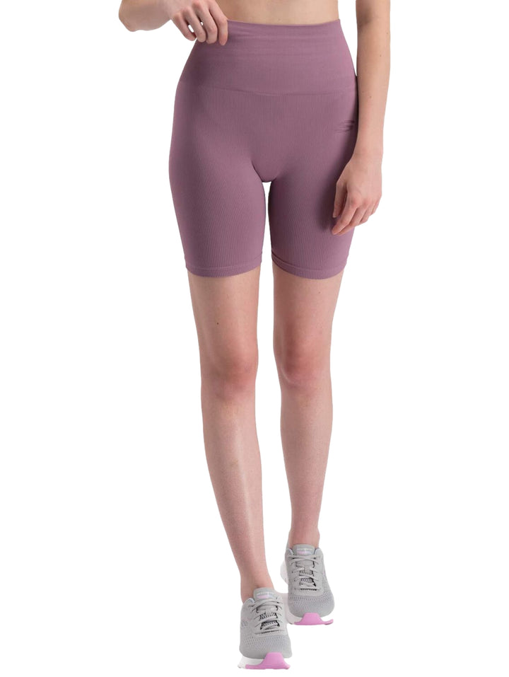 Mujer vistiendo shorts deportivos ajustados de color violeta de la marca Skechers.