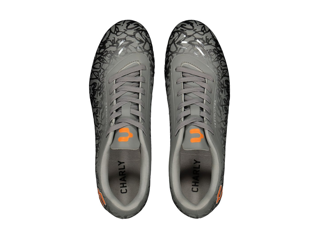 Calzado de fútbol Charly color gris con diseño gráfico negro y detalles naranjas.