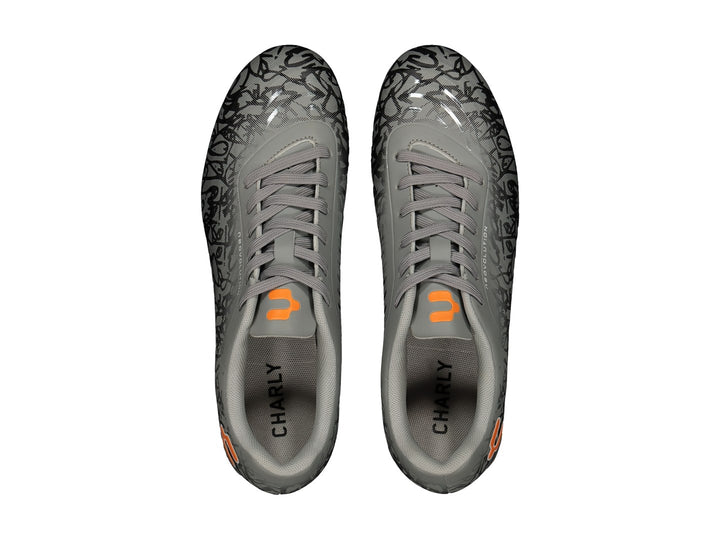 Calzado de fútbol Charly color gris con diseño gráfico negro y detalles naranjas.