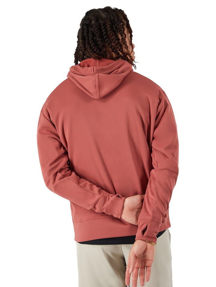 Hombre vistiendo una sudadera con capucha color rojo arena de la marca Champion con logotipo blanco frontal.