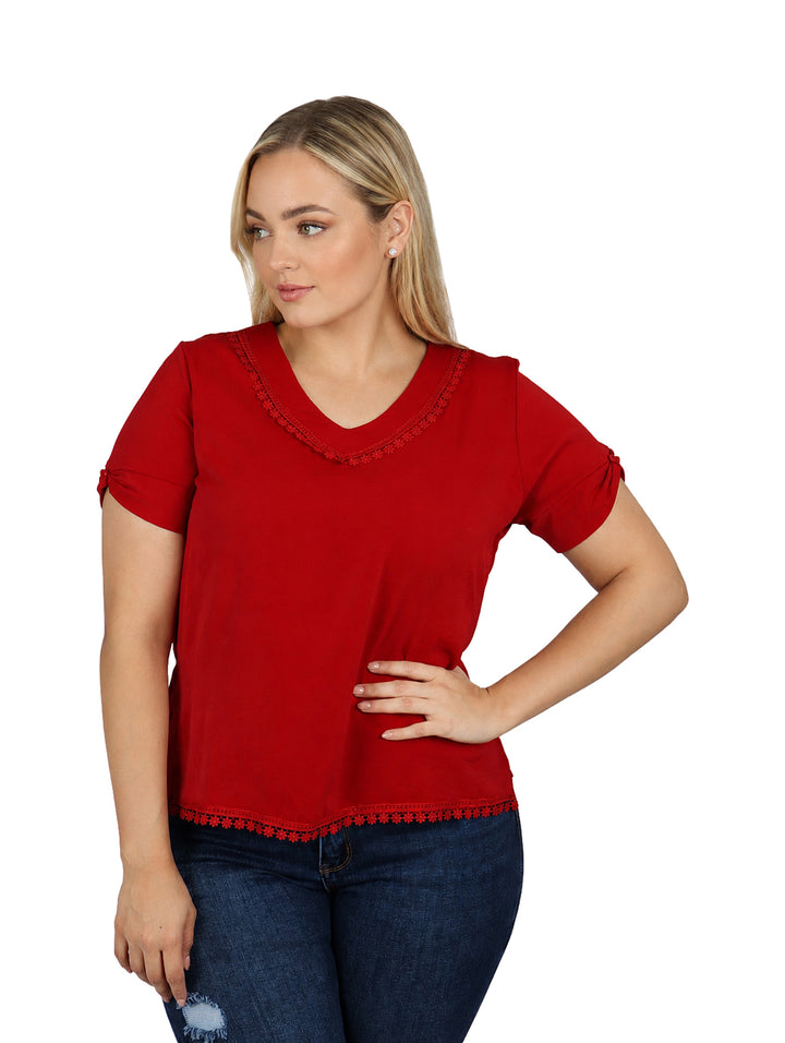 Mujer vistiendo blusa color rojo de manga corta con detalles decorativos en el cuello y el borde inferior.