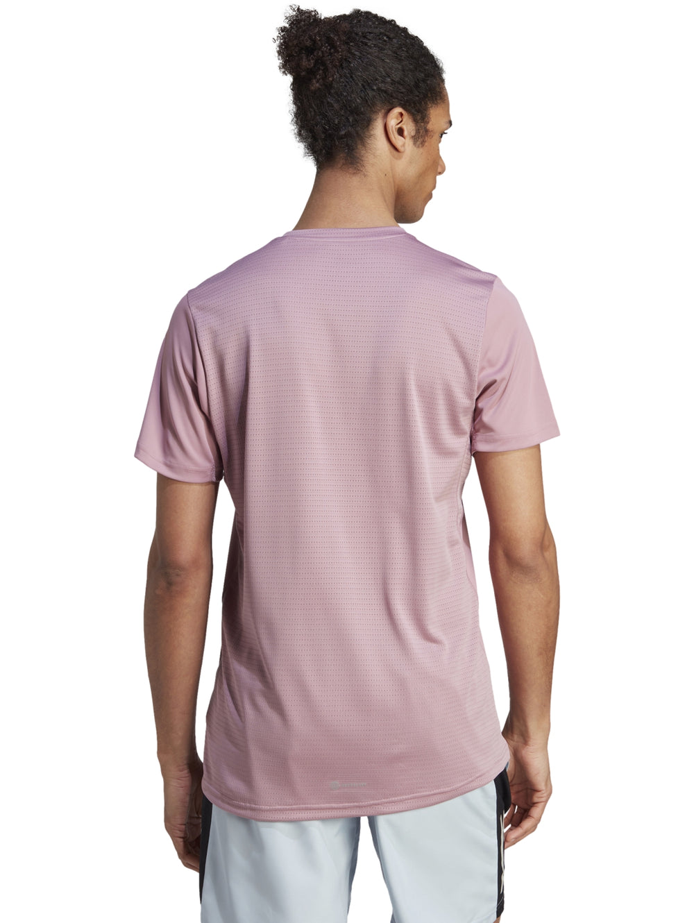 Camiseta deportiva Adidas de color morado claro con cuello redondo y manga corta.