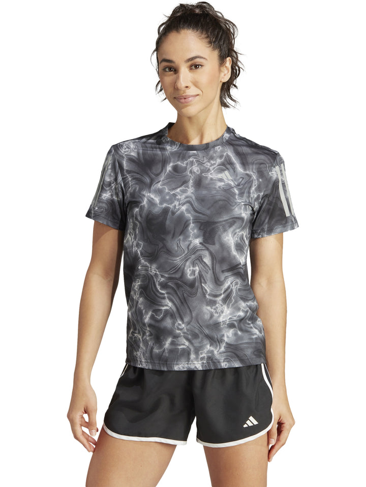 Camiseta deportiva Adidas de manga corta con estampado marmoleado en colores blanco, negro y gris.