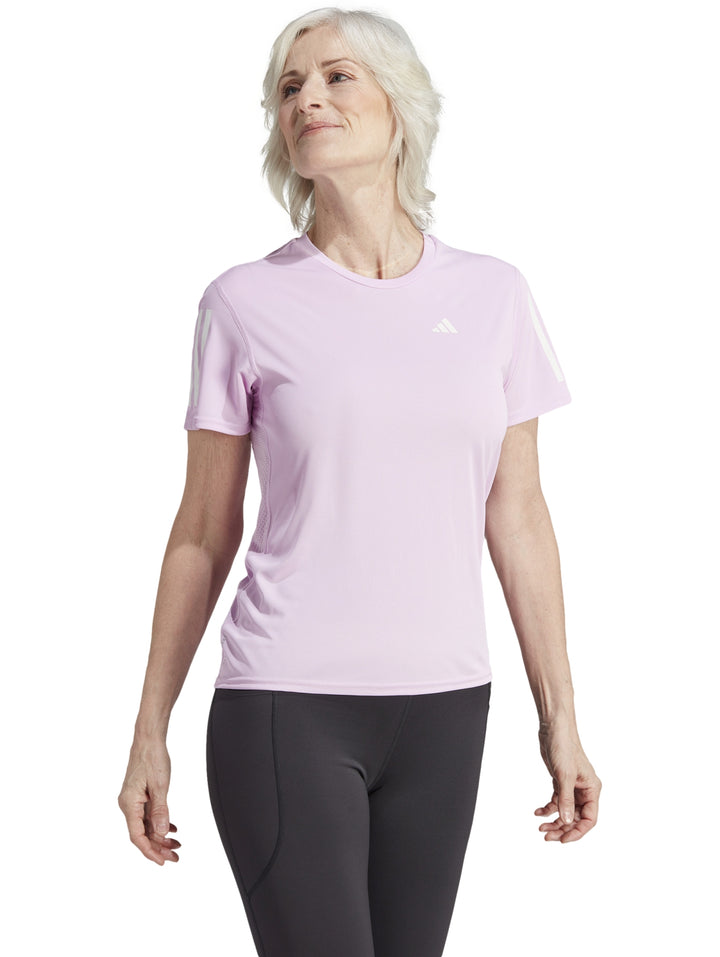 Mujer vistiendo camiseta deportiva Adidas color lila con detalles blancos en las mangas.