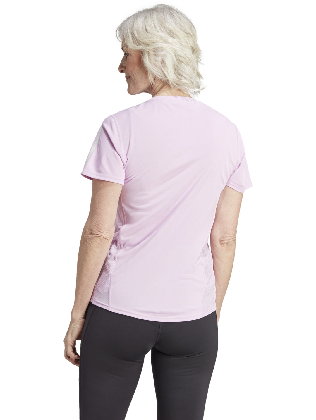 Mujer vistiendo camiseta deportiva Adidas color lila con detalles blancos en las mangas.