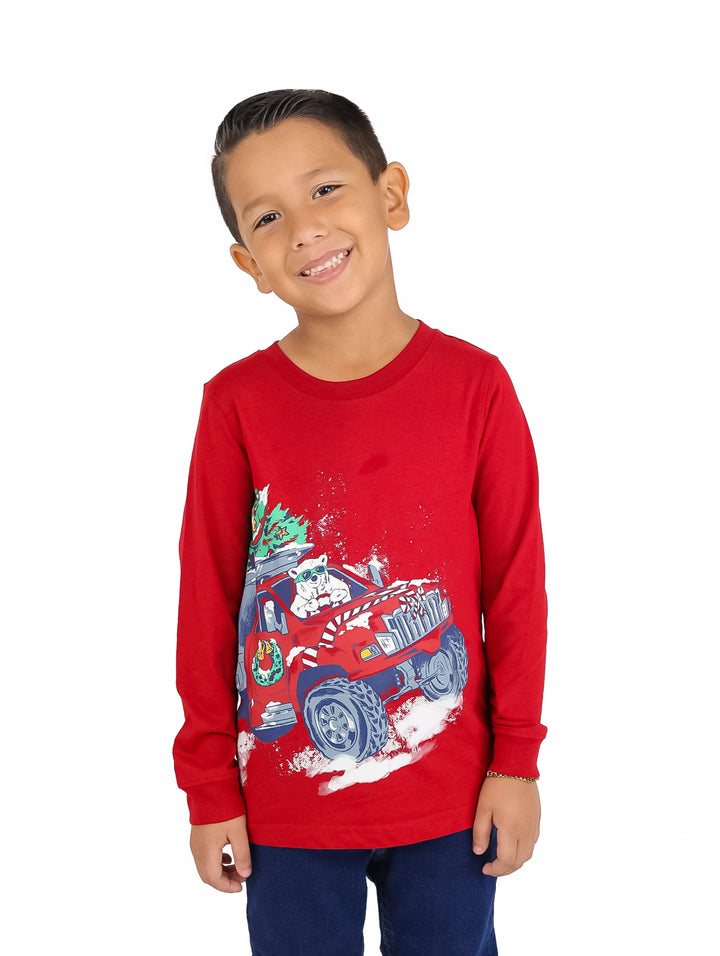 Niño vistiendo playera roja de manga larga con estampado de camioneta y perro blanco.