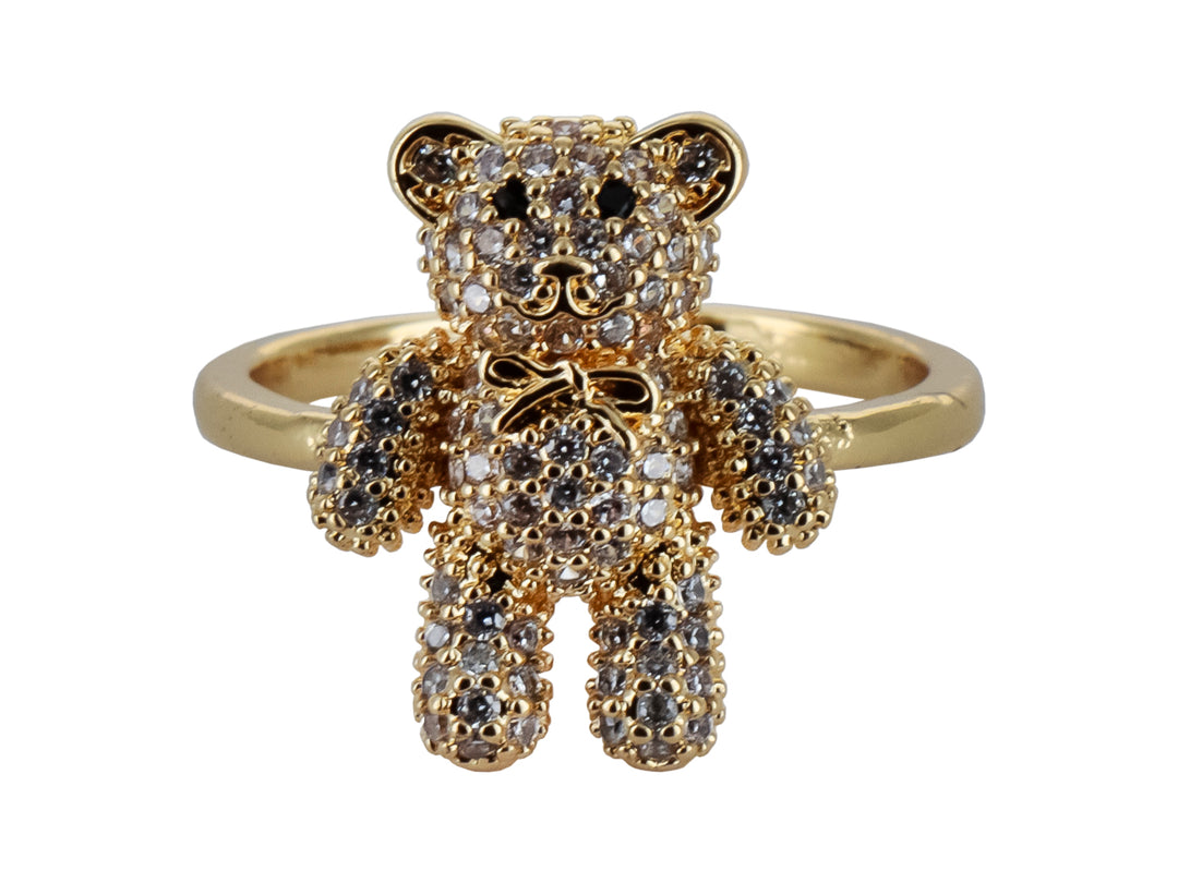 Anillo de color oro con un dije central en forma de oso cubierto de cristales brillantes.