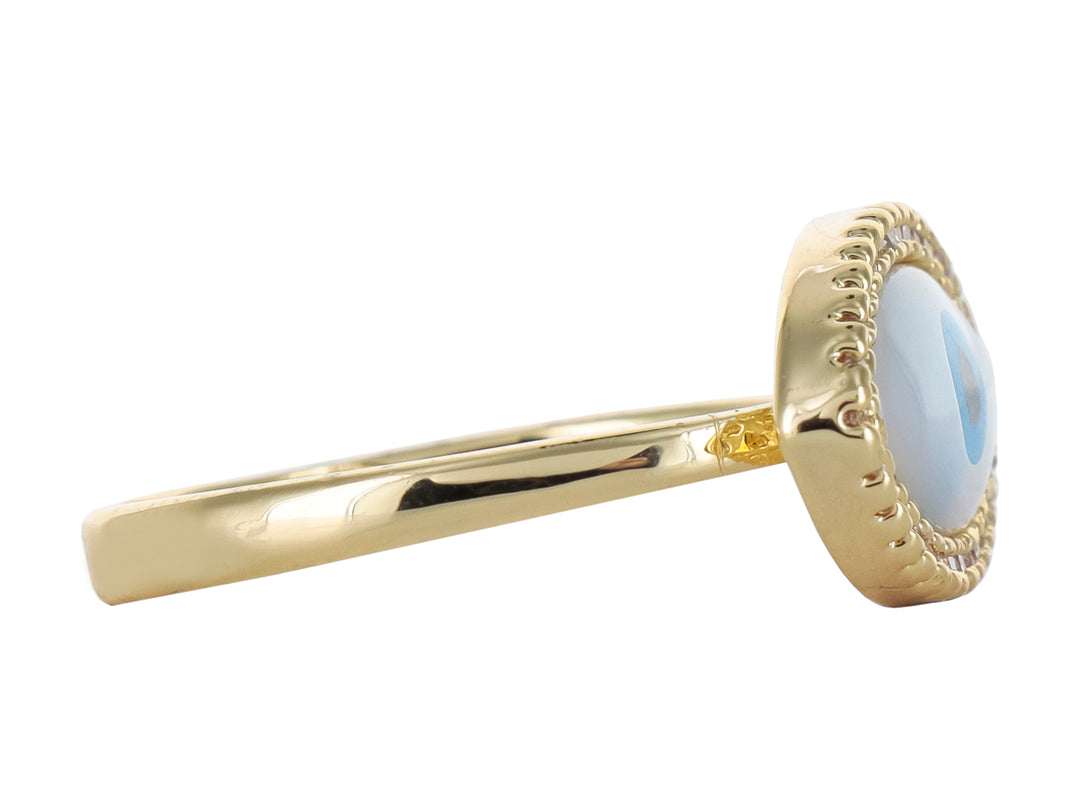 Anillo dorado con diseño de ojo turco en blanco y azul, rodeado de pequeñas piedras brillantes.