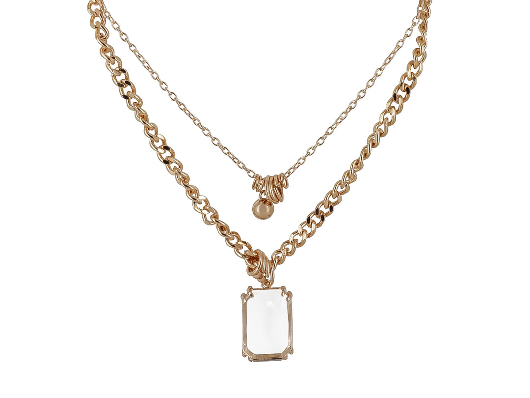 Collar de dos capas en color oro con un dije rectangular de cristal transparente y una pequeña esfera dorada.