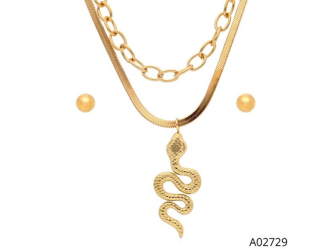 Set de joyería dorado compuesto por un collar de doble cadena con dije de serpiente y aretes de perla redondos.