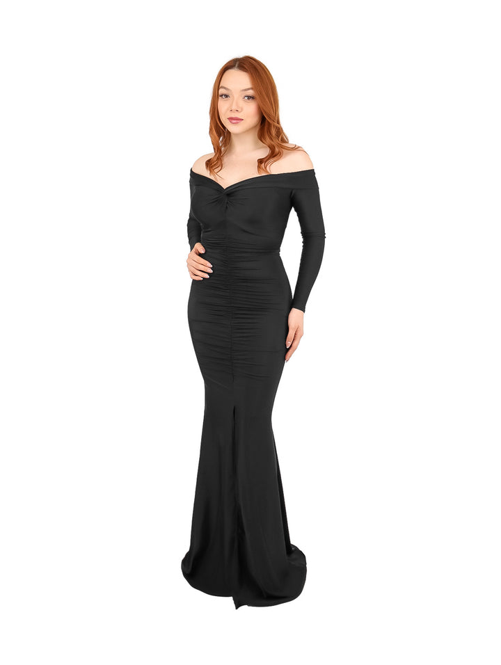 Mujer vistiendo un vestido largo ajustado de color negro con hombros descubiertos y mangas largas.