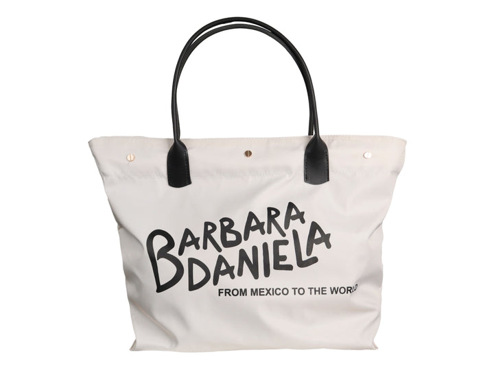 Bolsa tote color latte con asas negras y estampado de texto en color negro.
