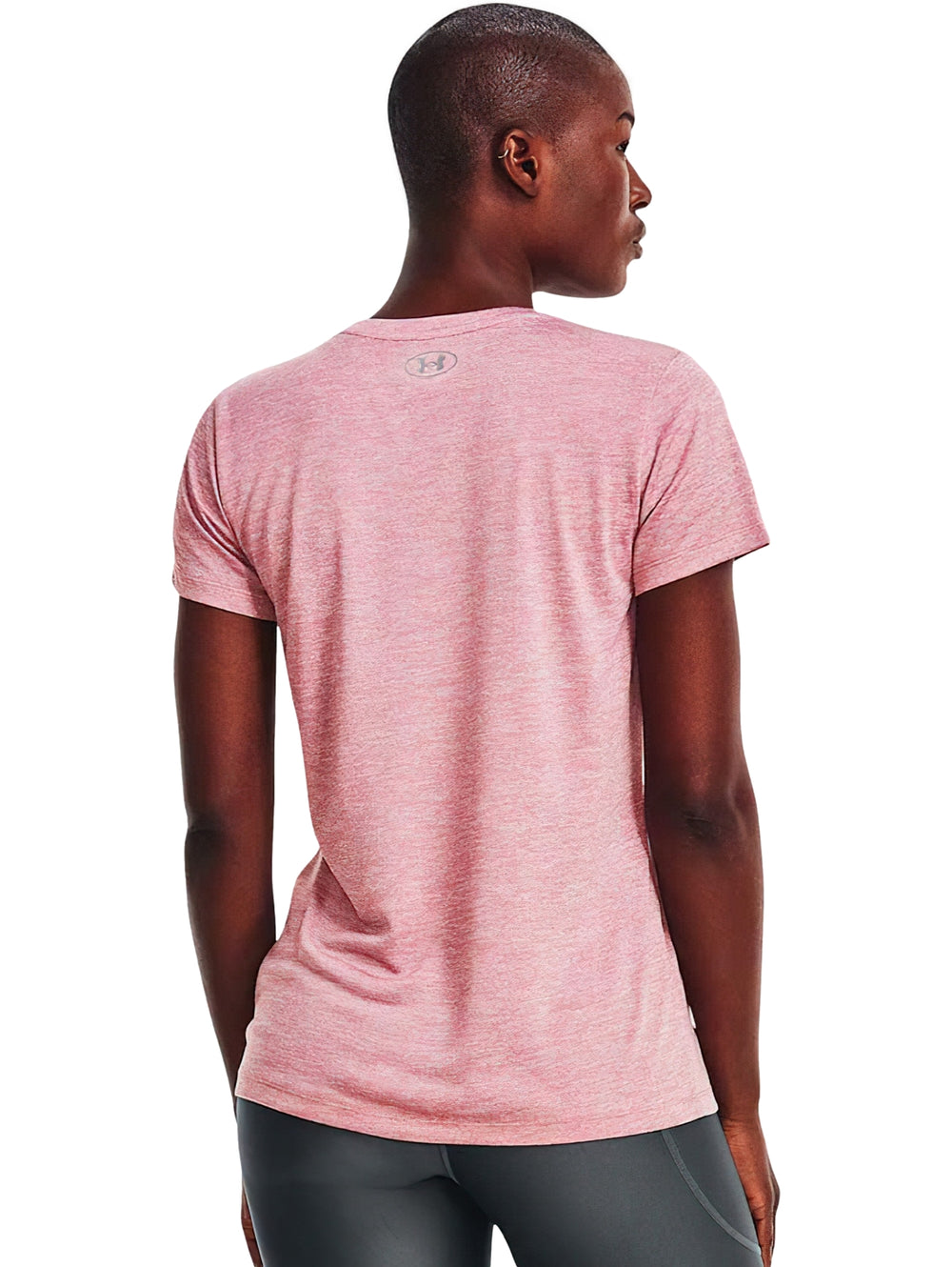 Mujer vistiendo una playera deportiva Under Armour de color rosa elixir con cuello en V y manga corta.