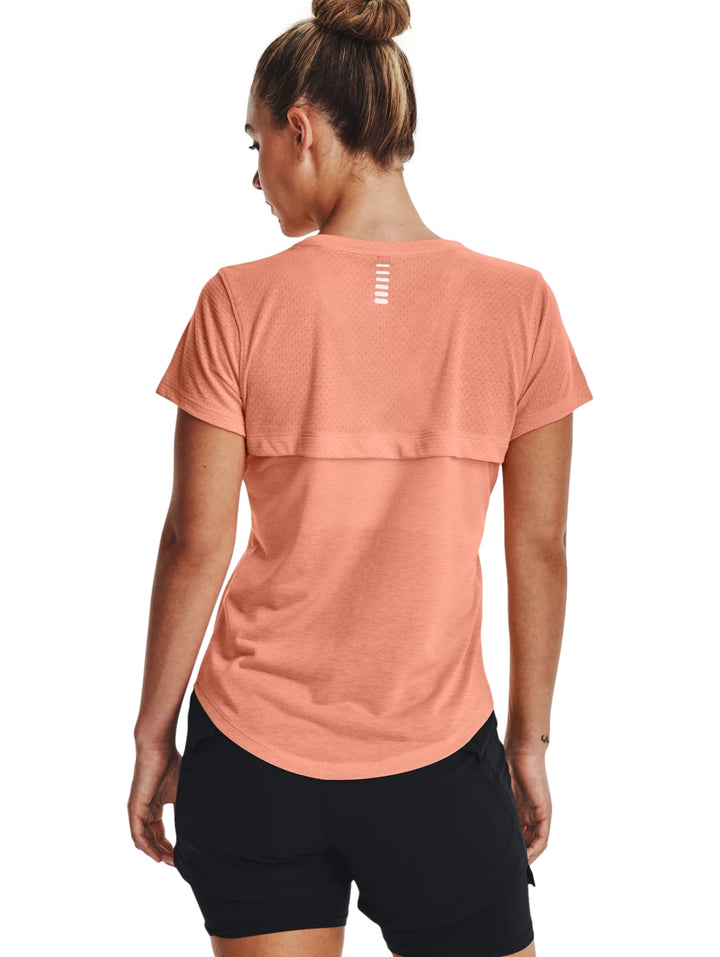 Mujer vistiendo una playera deportiva de manga corta color Bubble Peach de Under Armour.