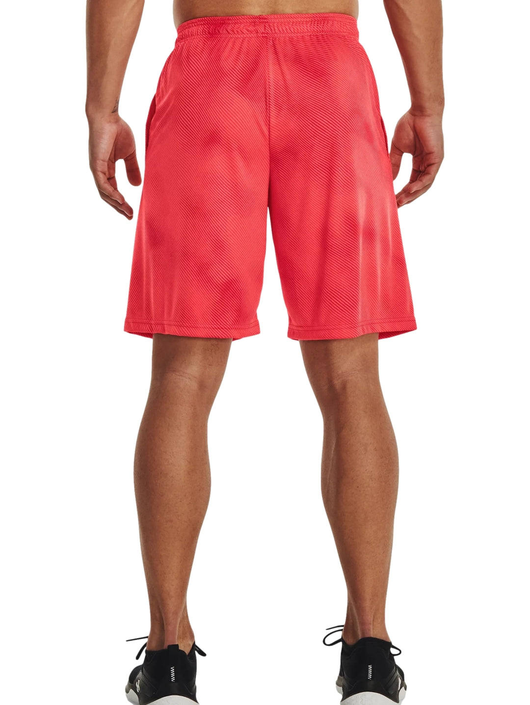 Hombre vistiendo shorts deportivos color rojo brillante de la marca Under Armour.