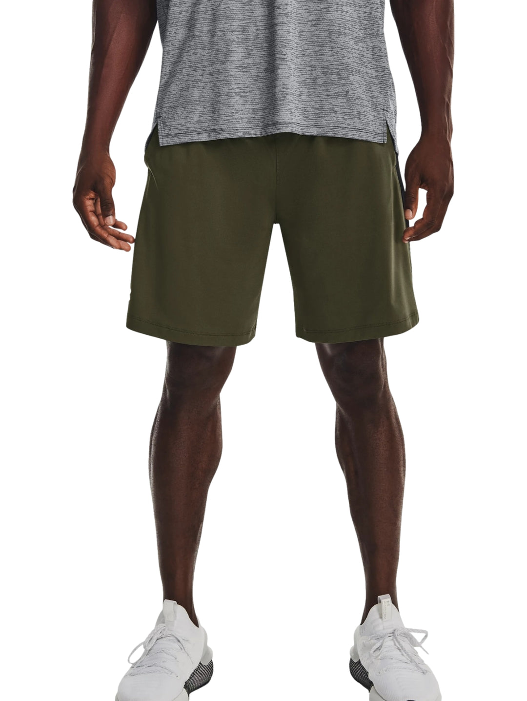 Hombre vistiendo pantalones cortos deportivos Under Armour en color verde oliva oscuro.