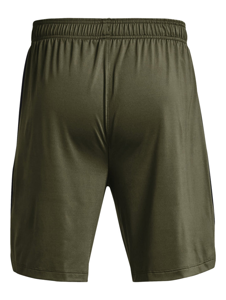 Hombre vistiendo pantalones cortos deportivos Under Armour en color verde oliva oscuro.
