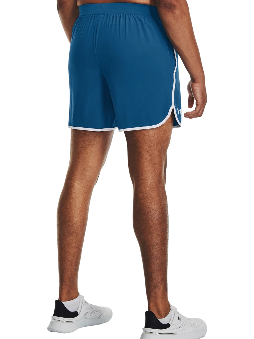 Hombre vistiendo shorts deportivos color azul con ribete blanco de la marca Under Armour.