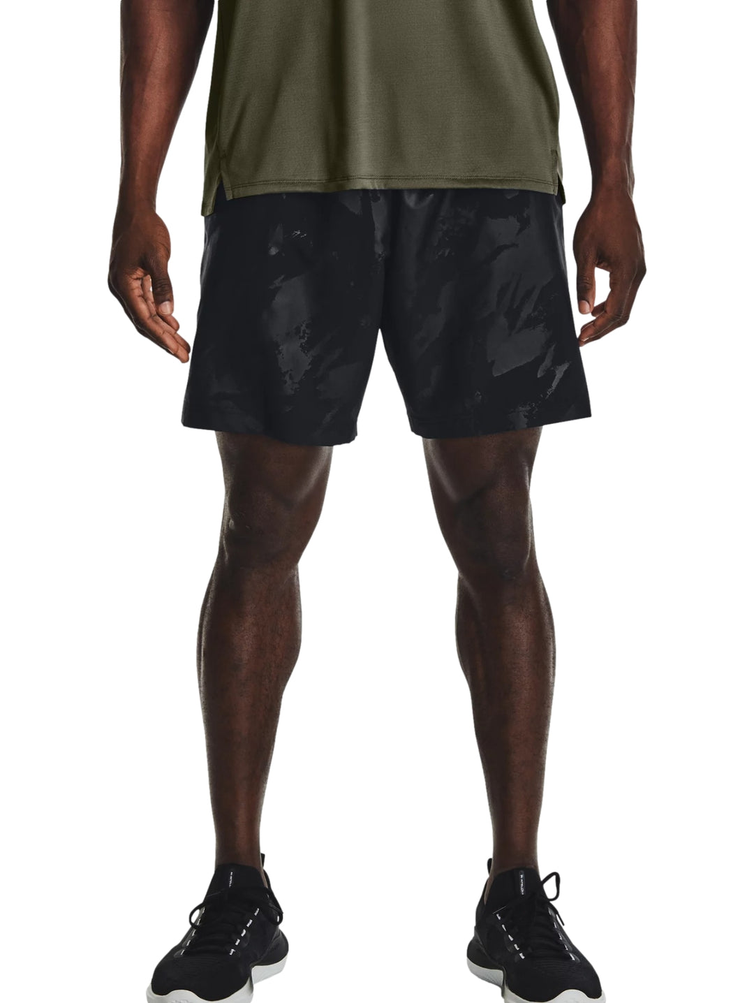 Hombre vistiendo shorts deportivos negros con un patrón grabado sutil de la marca Under Armour.
