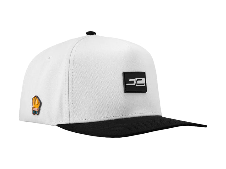 Gorra snapback blanca con visera plana negra y logotipos JC en contraste.