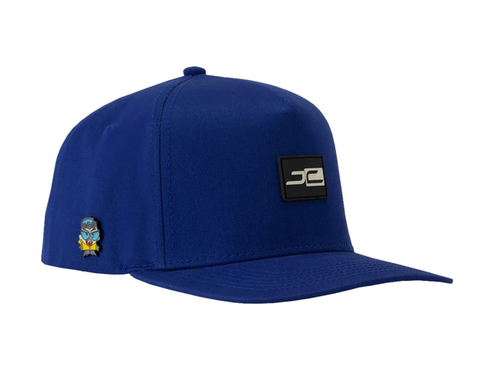 Gorra snapback de color azul con visera plana y logotipo JC en el frente y lateral.