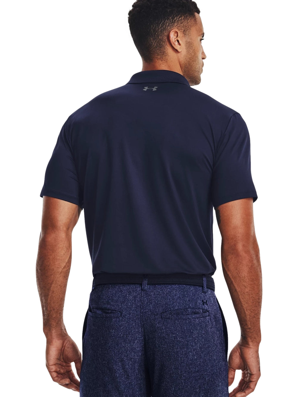Hombre vistiendo una playera polo Under Armour de color azul marino con logotipo en el pecho.