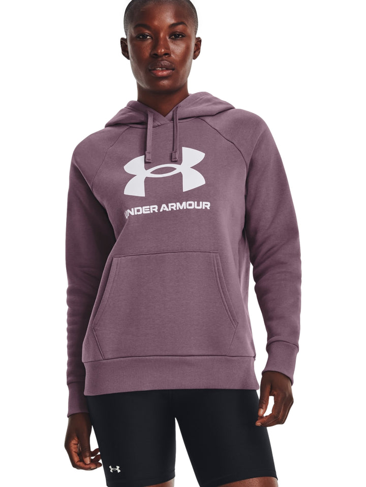 Mujer vistiendo sudadera con capucha color morado con logo blanco de Under Armour en el pecho.